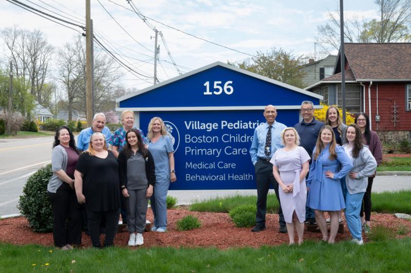 a group of people in front of a sign